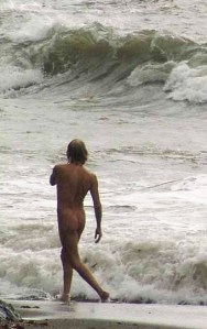 home nu preciós passejant davant onades mar