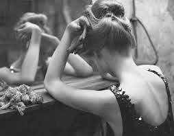 dona davant mirall trista cara tapada