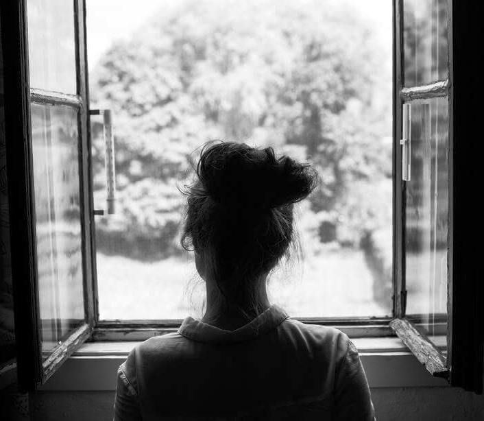 dona noia mirant per la finestra la tarda b i n 000