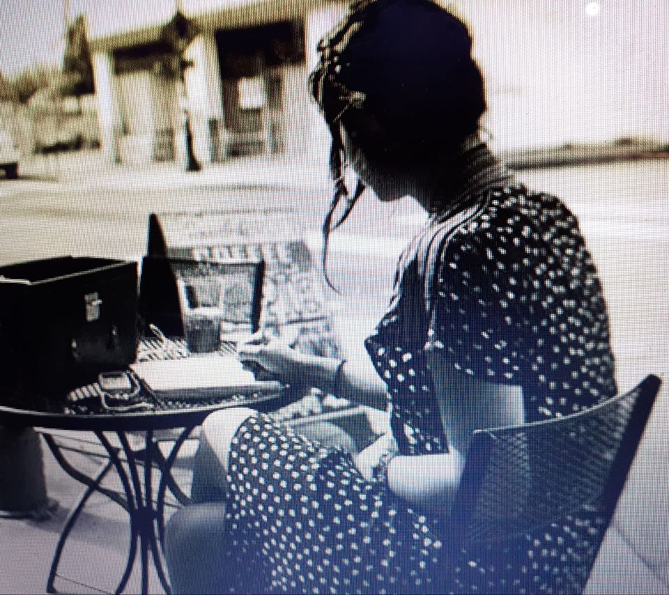 noia dona escrivint a terrassa de bar